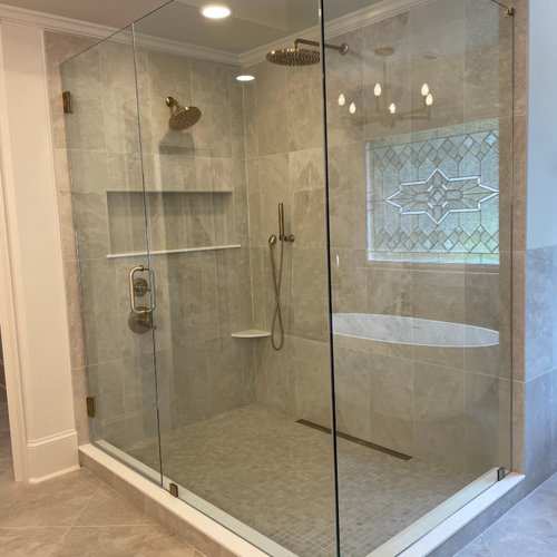 Grey tile shower installation with glass walls