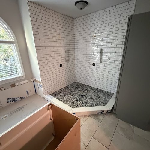 White subway tile in a corner shower