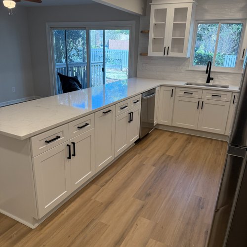 White kitchen cabinets with black hardware in a cozy kitchen
