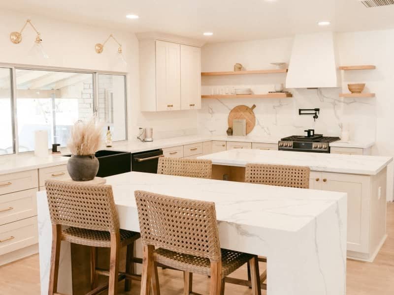 Kitchen with a white waterfall island and sleek white cabinets