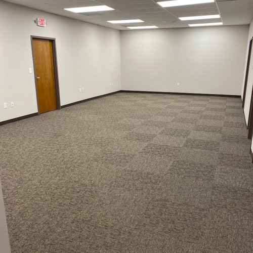 Corporate office with overhead lighting and brown carpet tiles