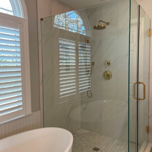 New shower with glass walls and gold accents