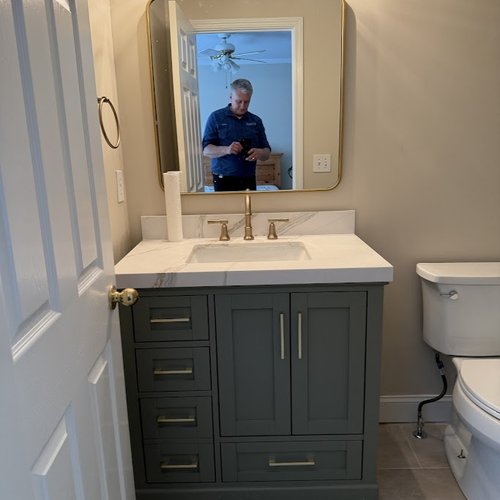 Grey and gold cabinets in a bathroom of an Alpharetta, GA home