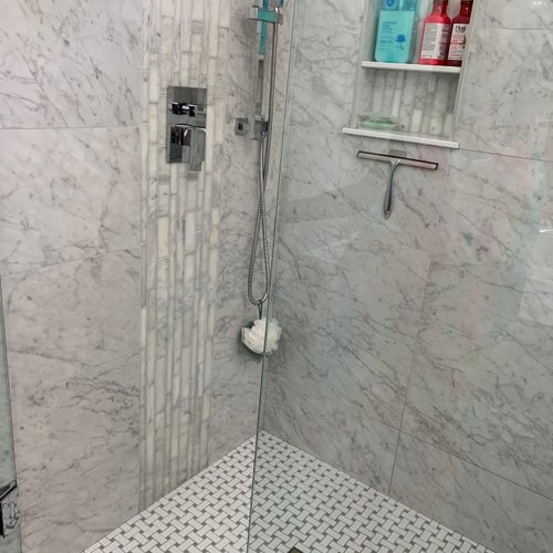 Shower with detailed patterned grey and white tiles