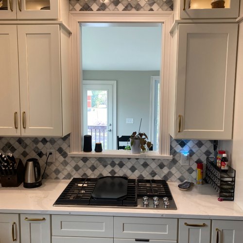 White cabinets in a kitchen with a patterned tile backsplash