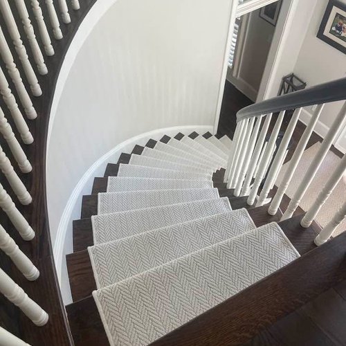 Spiral staircase with white patterned stylish stair runner