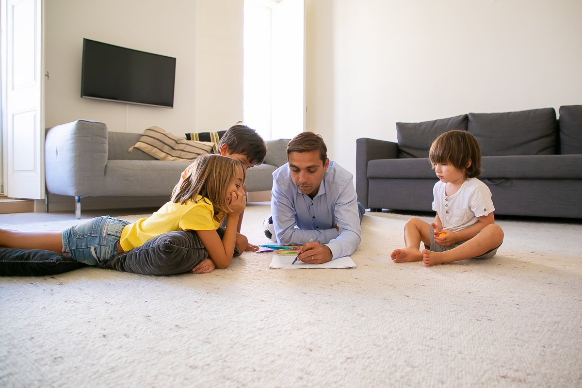 Dad and kids drawing on carpet floor