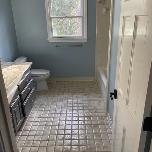 Bathroom with blue painted walls and outdated tile flooring