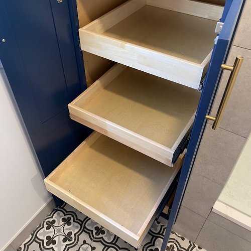 Blue storage cabinet in a bathroom with mosaic tile floors
