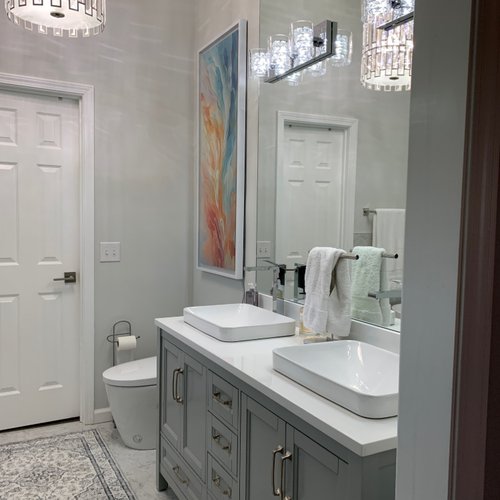 Traditional style bathroom with a chandelier and grey cabinets