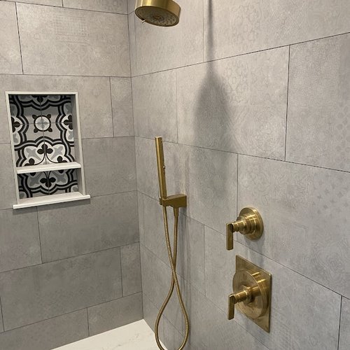 Shower with grey tiles and gold hardware accents