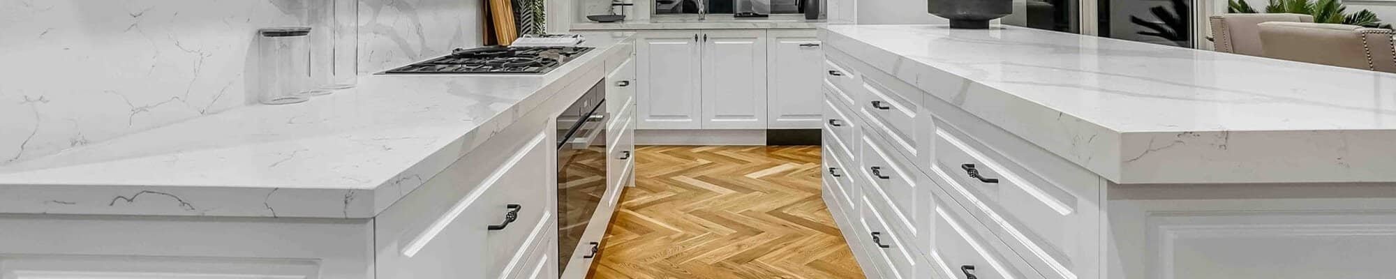 Kitchen with white cabinets and warm hardwood flooring