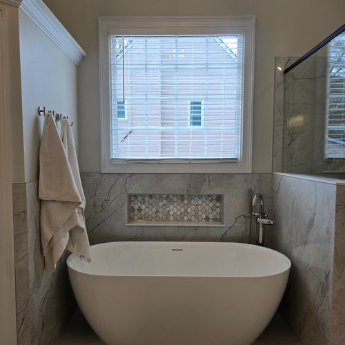 Grey tile wall around a new bathtub